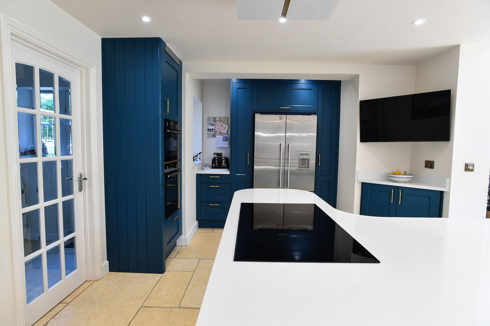 Modern Kitchen Living kitchen with navy feature wall, white handleless cabinetry, black worktop and breakfast bar seating