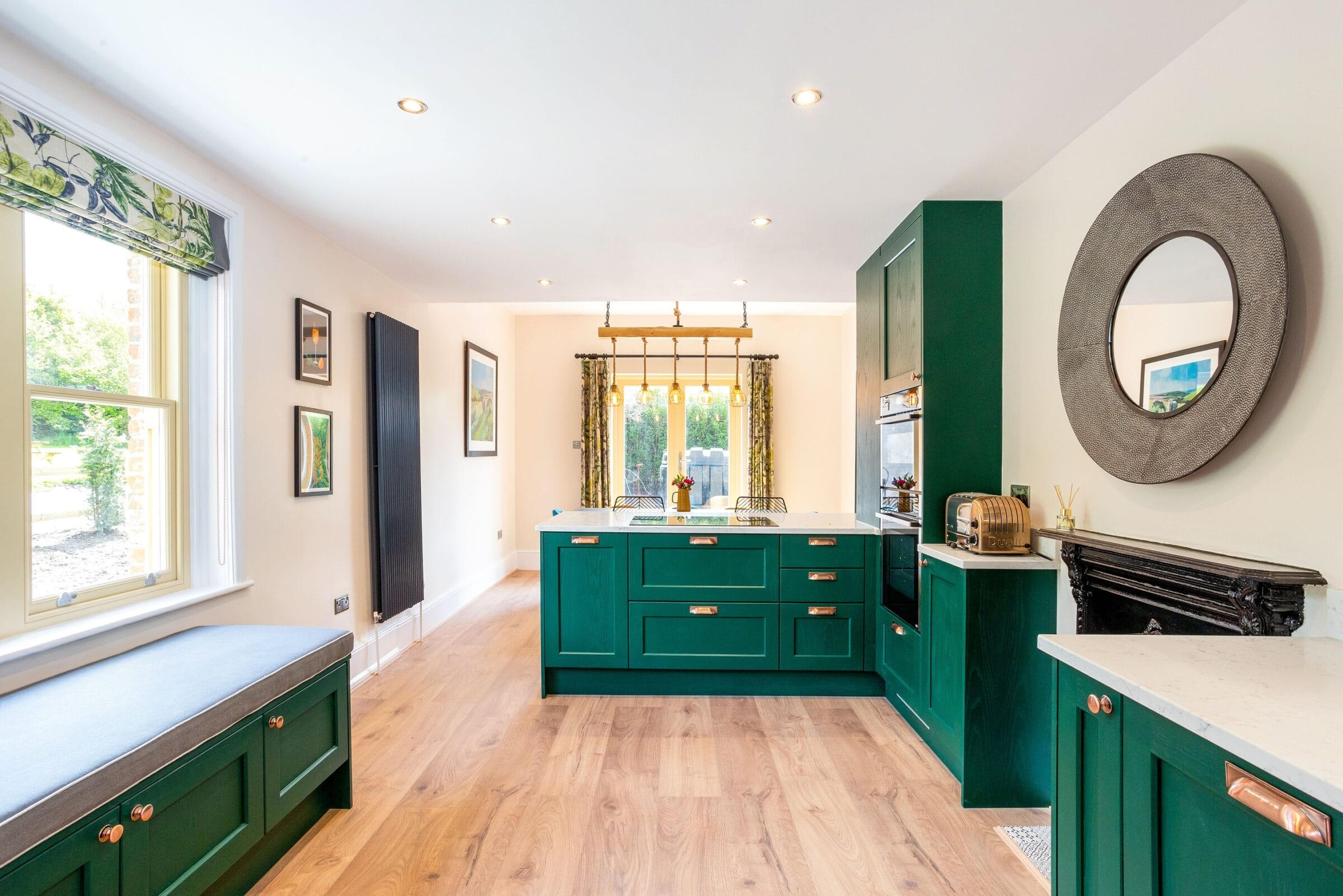Long green Kitchen Living kitchen with marble worktops, herringbone flooring, wall mirror and bright natural light