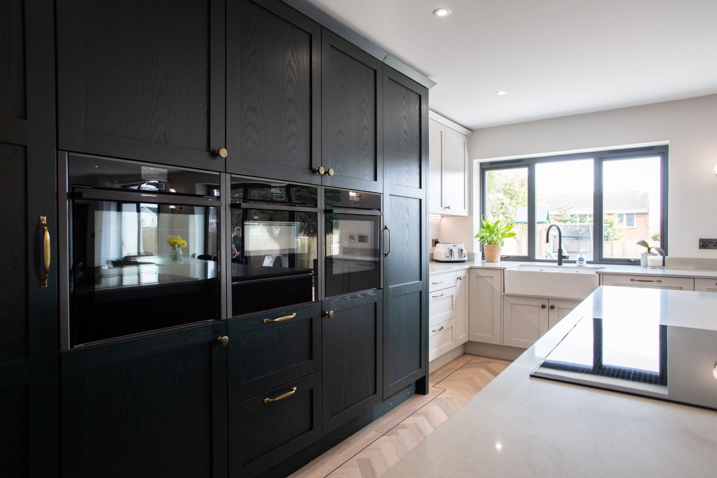 Modern Kitchen Living kitchen with black cabinetry, integrated appliances, breakfast bar and bright garden view