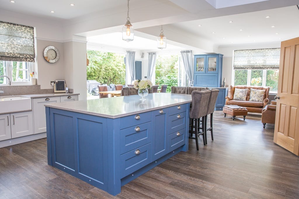 Blue Kitchen Living island with quartz worktops, classic cabinetry, wooden flooring and bright open-plan seating area