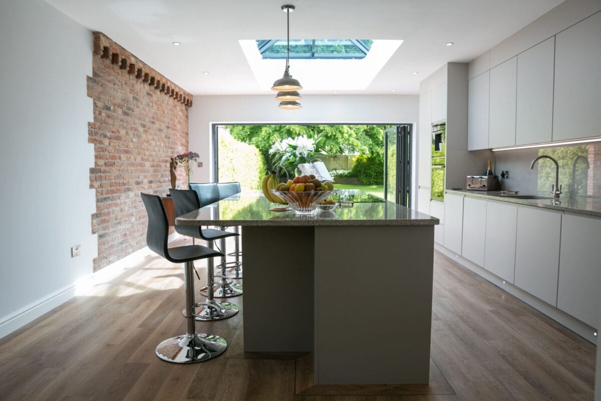 Modern bespoke kitchen with island, skylight and handleless cabinetry by Kitchen Living