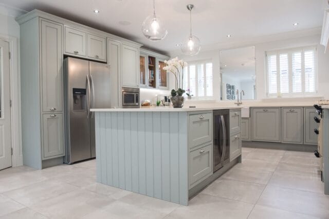 Soft grey Kitchen Living kitchen with central island, shaker cabinetry, integrated appliances and elegant pendant lighting