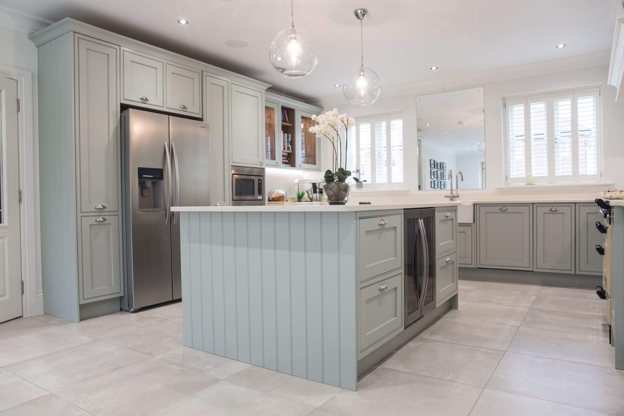 Soft grey Kitchen Living kitchen with central island, shaker cabinetry, integrated appliances and elegant pendant lighting