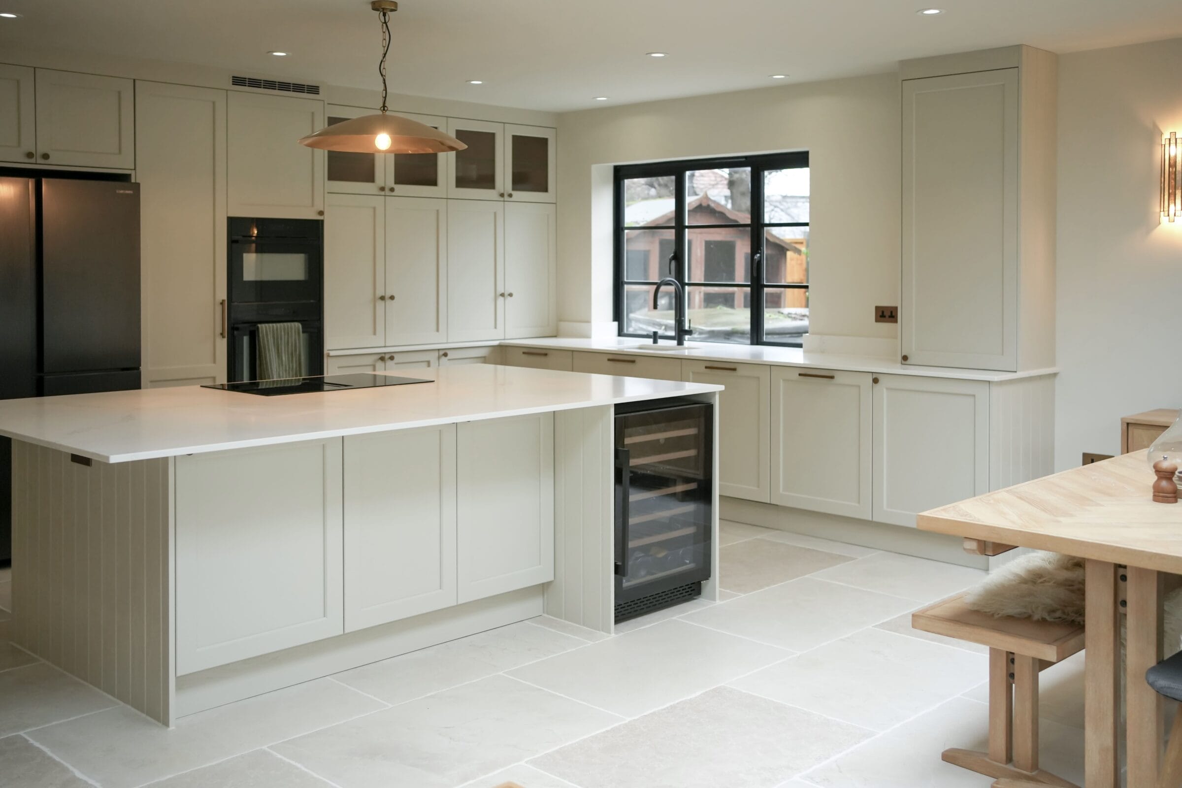 Modern open-plan Kitchen Living kitchen with white cabinetry, marble worktops, island seating and black framed glass doors