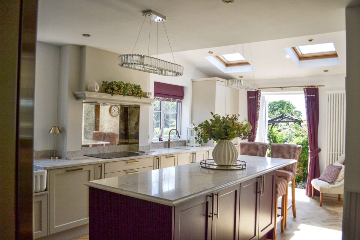 Bright shaker kitchen with central island, skylights, stone worktops and open-plan dining area