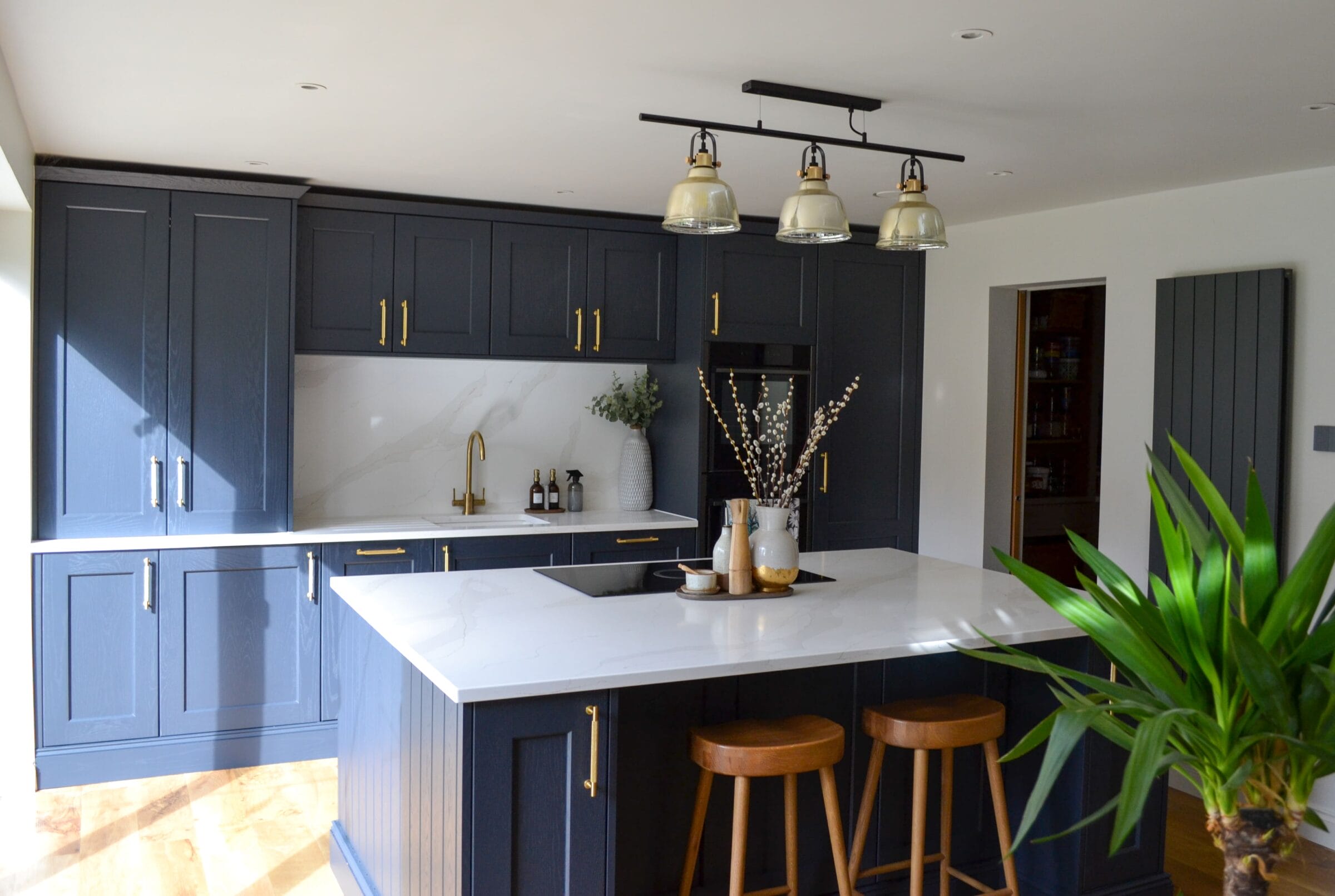 Grey handleless kitchen with granite island, exposed brick feature wall and lantern roof light in a Hampshire home extension by Kitchen Living